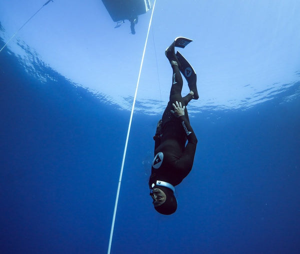 Freedive diving with Alchemy Neck Weight in white.