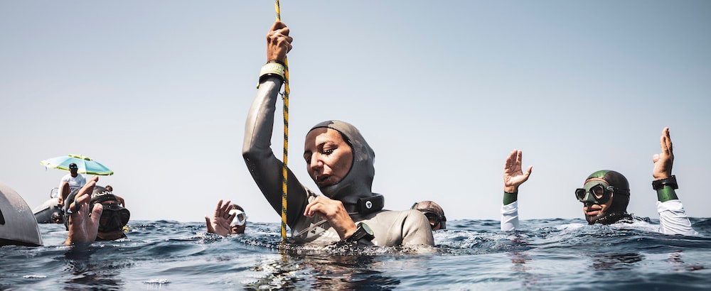 Female freediver getting ready for open water dive, wearing Alchemy Neck Weight in Black